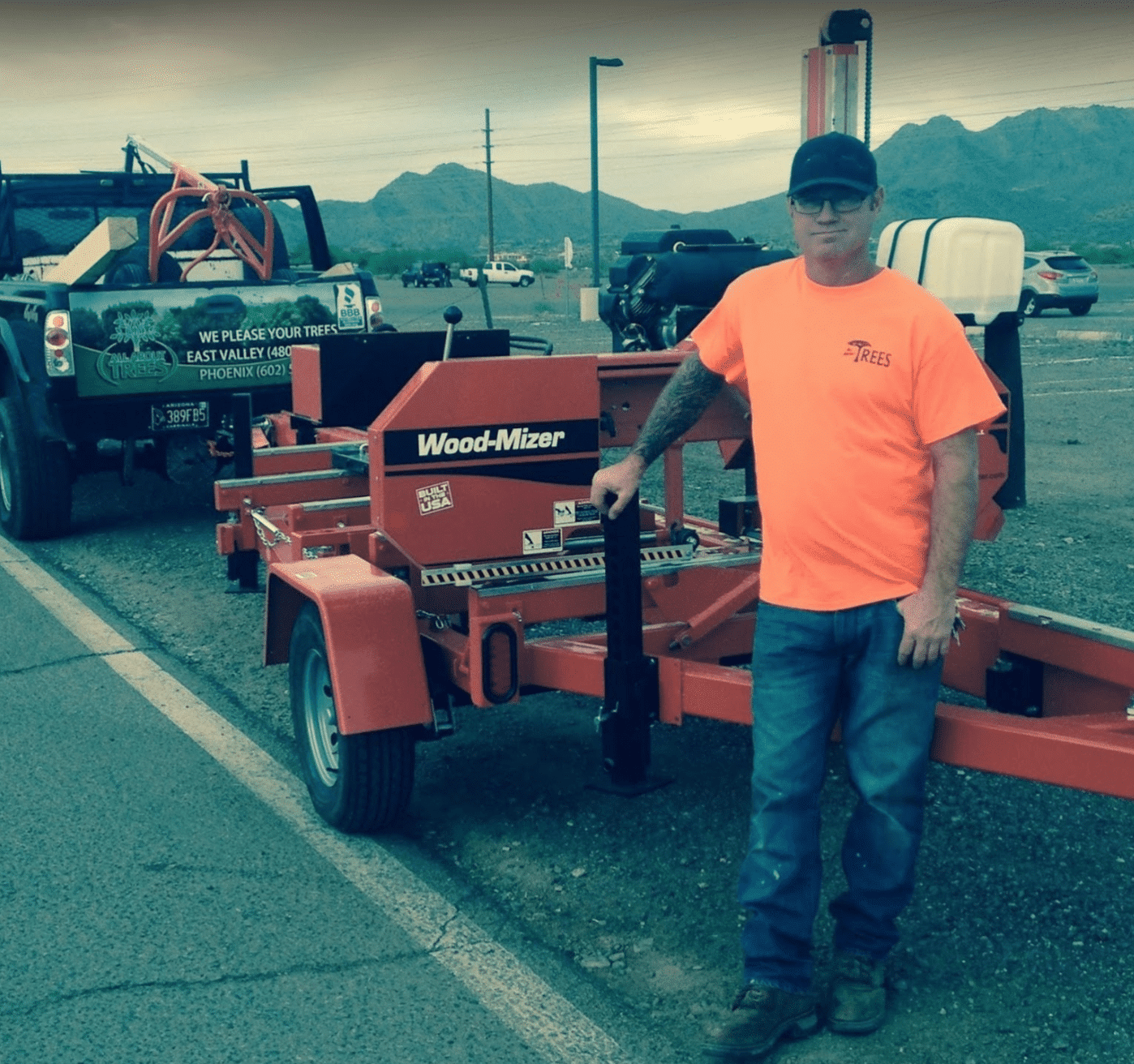 Man standing by Wood-Mizer sawmill trailer.